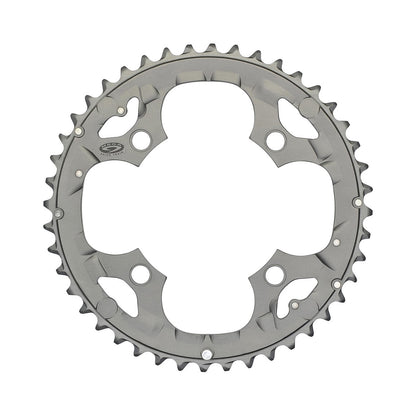 Corona esterna SHIMANO DEORE M590 9 velocità, 4 fori, 104 mm, argento — vista della corona su sfondo bianco
